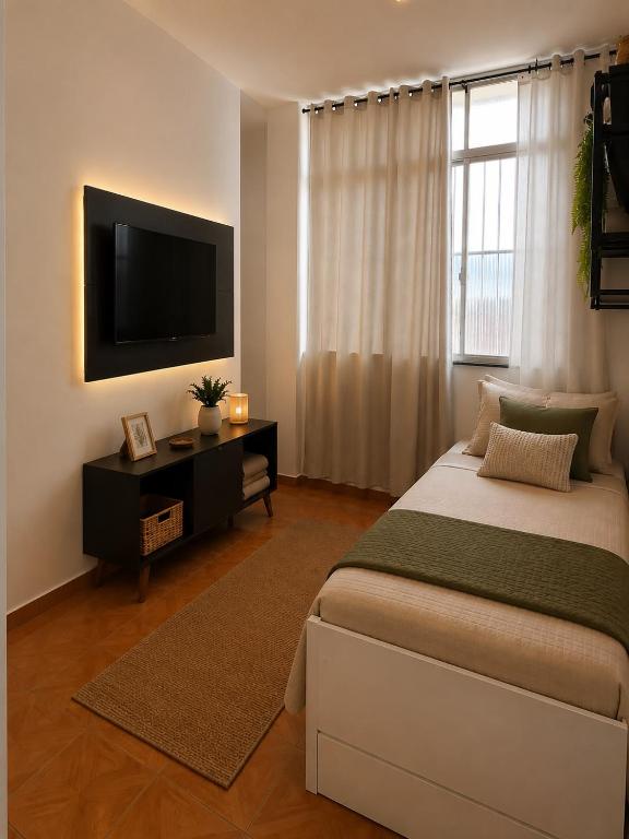 a bedroom with a large bed and a television at Copacabana Rooms & Hostel in Rio de Janeiro