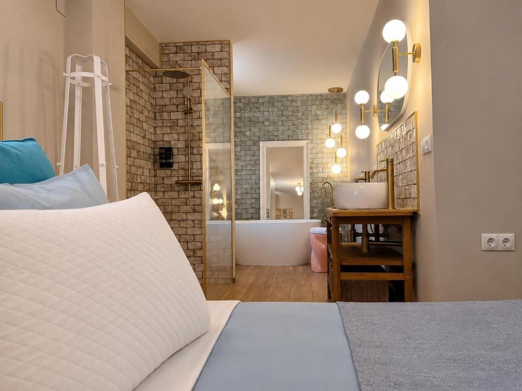 a bedroom with a bed and a bathroom with a tub at Casa Rosetta Boutique in Xàtiva
