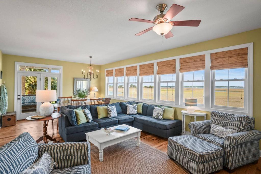 a living room with blue couches and a ceiling fan at Harbor Island 71 Harbor Drive in Nautical Watch Villas