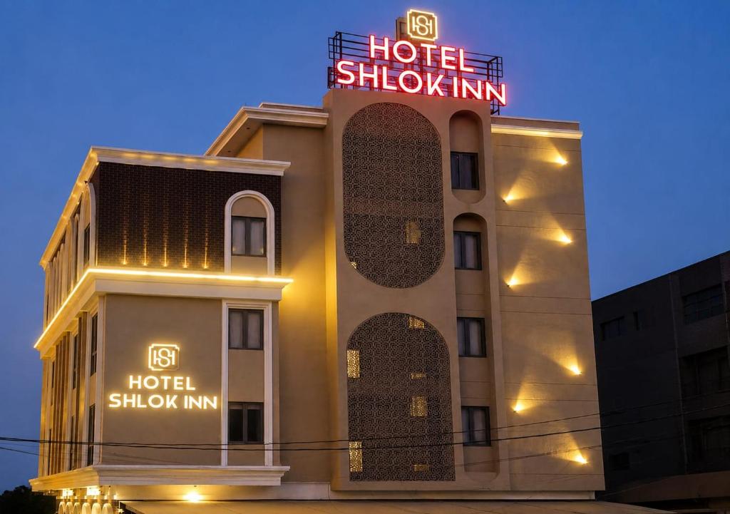 a hotel with a sign on the side of a building at Hotel Shlok Inn in Somnath