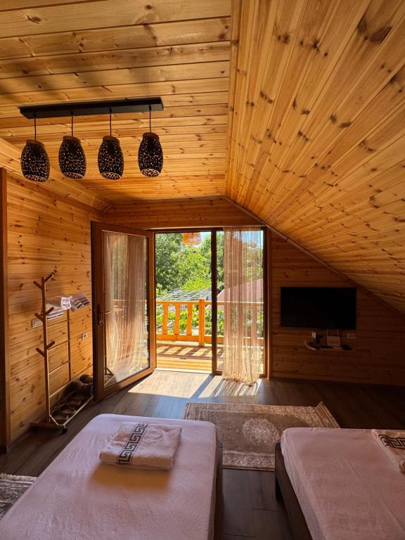 a room with two beds and a television in a cabin at Naimi in Pukë