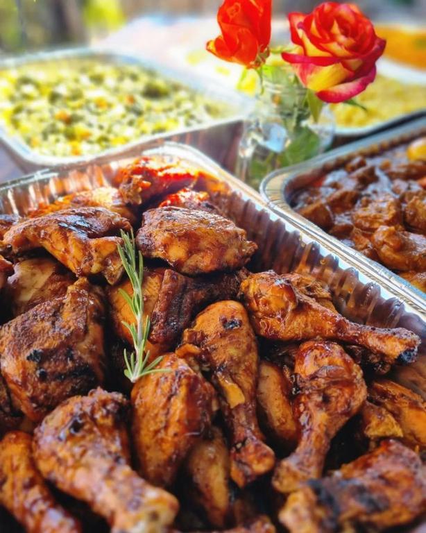 a buffet of food with chicken and other foods at BelizeprivateChef in Dangriga
