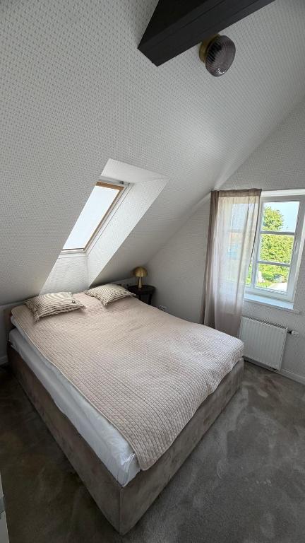 a bedroom with a bed and two windows at Lotmiškio 1 in Neringa