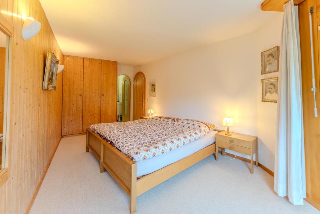 a bedroom with a bed and a table with a lamp at Charmante Wohnung im Dorfkern in Klosters
