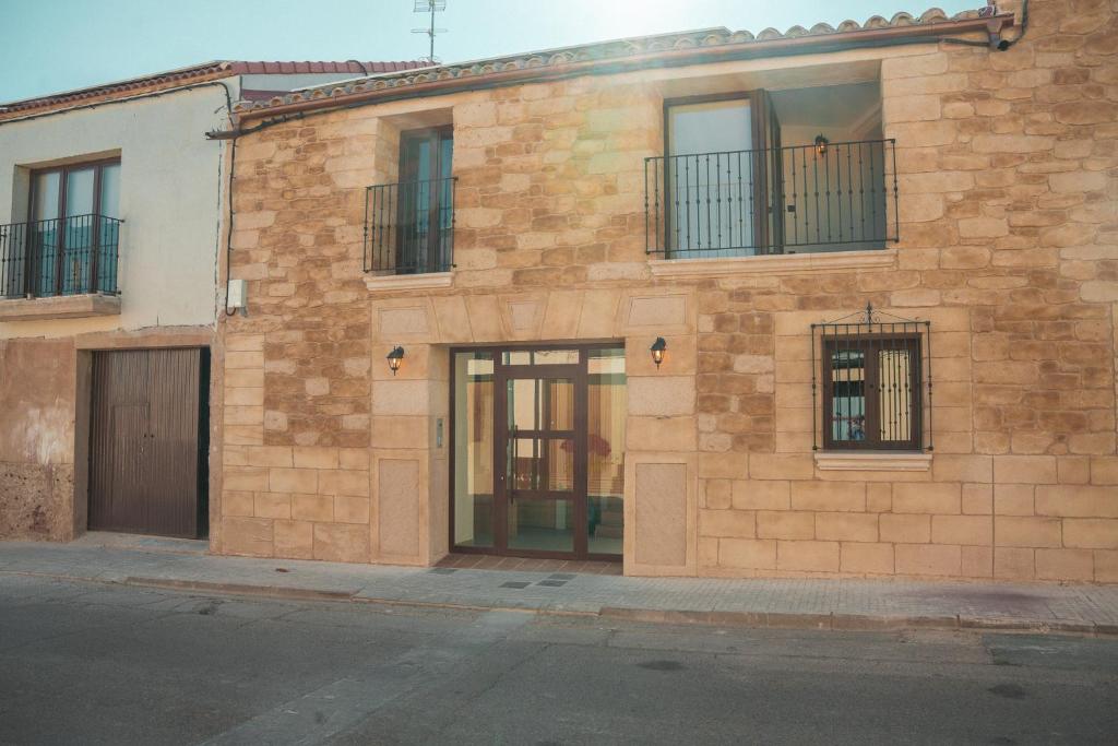 a brick building with windows and doors on a street at Casa 'El Tio Pedro' in Alcañiz