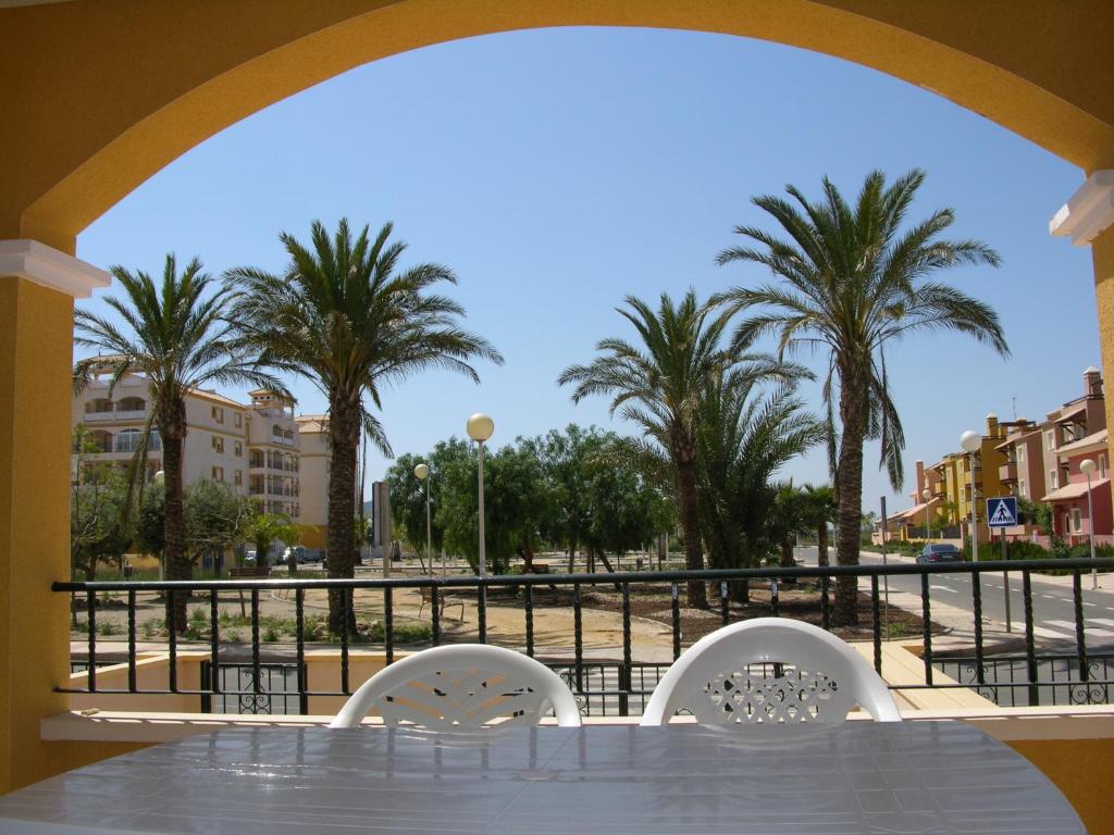 a table and chairs with palm trees in the background at Ribera Beach 2 - 0905 in Mar de Cristal