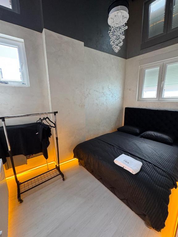 a bedroom with a black bed with a white book on it at A&S apartmani 2 in Smederevo