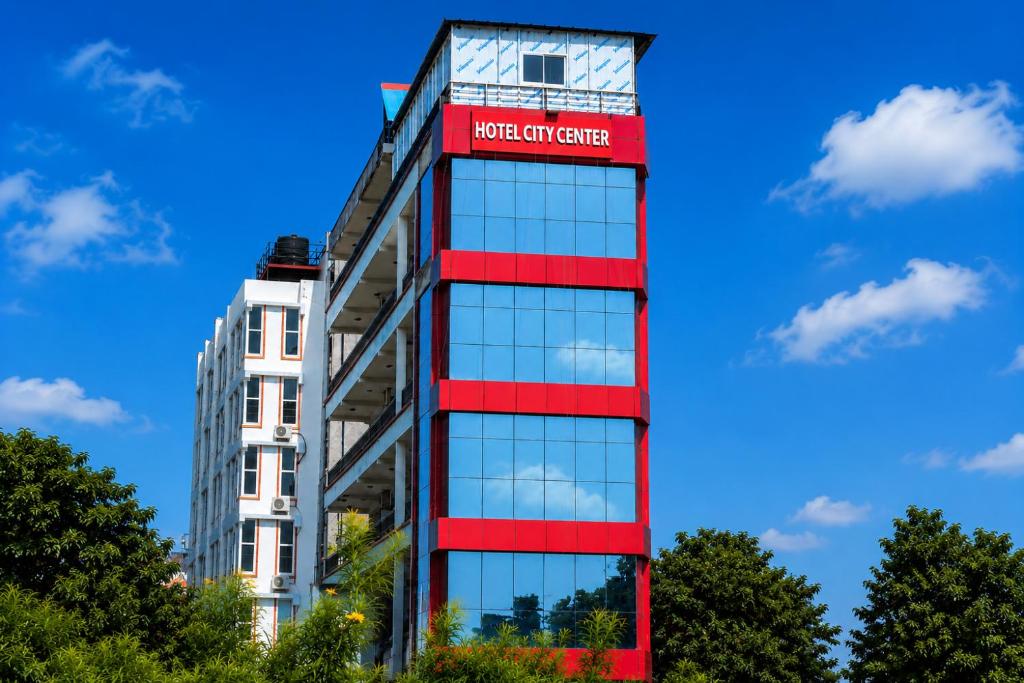 a tall building with a red and white sign on it at Hotel City Center in Bhairāhawā