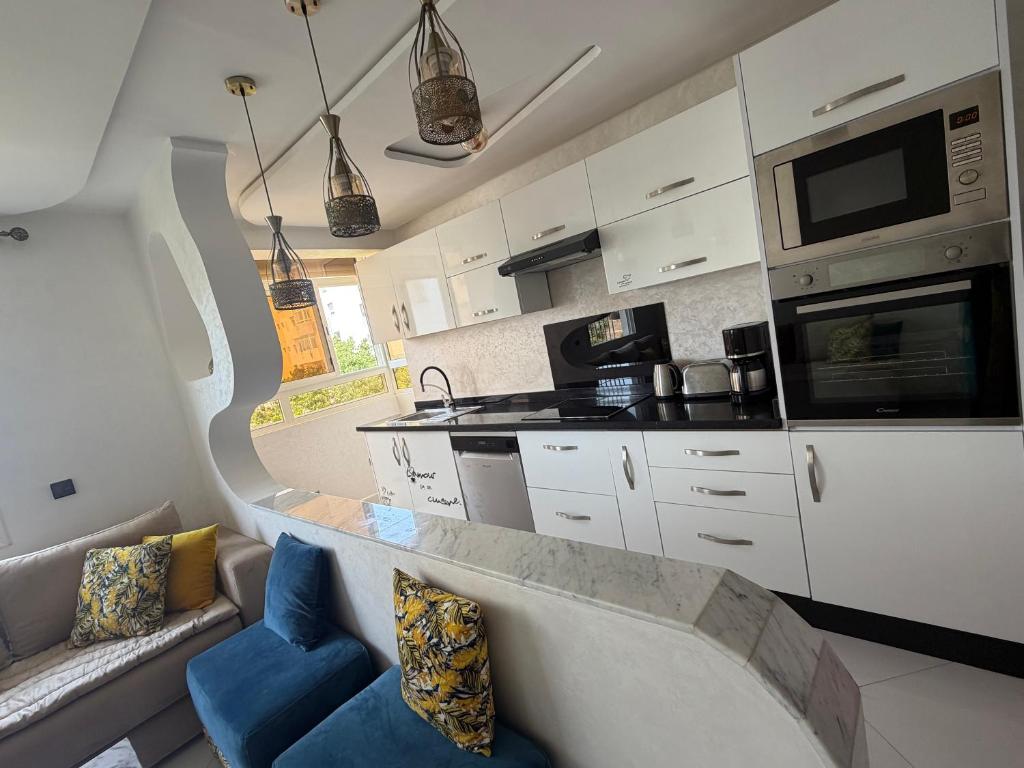 a living room with a couch and a kitchen at perle rare plage des Nations in Sidi Bouqnadel