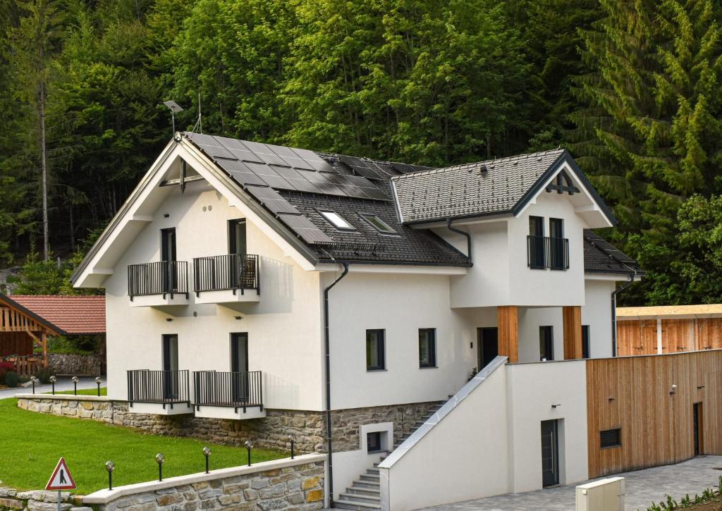 a house with a black roof at Apartmaji Vouk - sodobni apartmaji v objemu narave - Lukanja - Rogla - Primerno za pare in družine - Sprostitev in aktivno preživljanje prostega časa in Oplotnica
