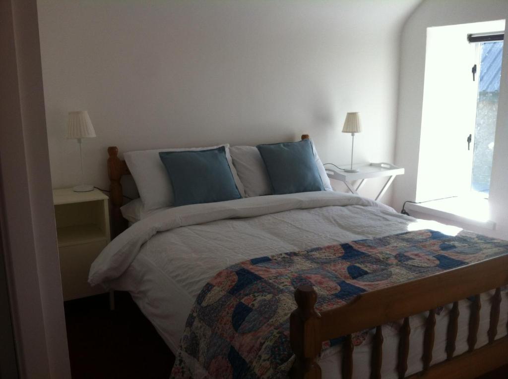 a bedroom with a large bed with blue pillows at Room 3 Camp Street B&B in Oughterard