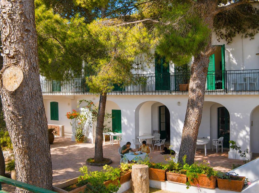 two people sitting at a table in front of a building at Villa Stasi B&B in Leuca