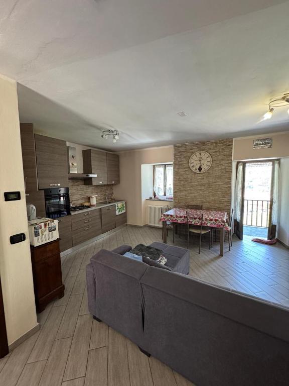 a large living room with a couch and a kitchen at La casa dei Ruc in Capo di Ponte