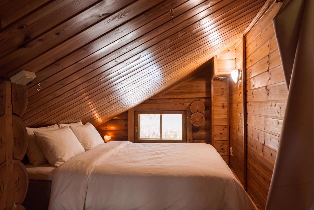a bedroom with a bed in a wooden cabin at Northern Nest by Elys Collection in Kittilä