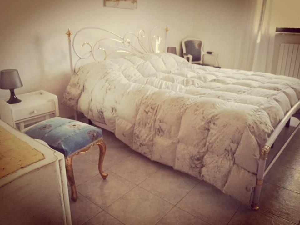 1 dormitorio con 1 cama grande y edredón blanco en Vacanze in Puglia, en Capurso