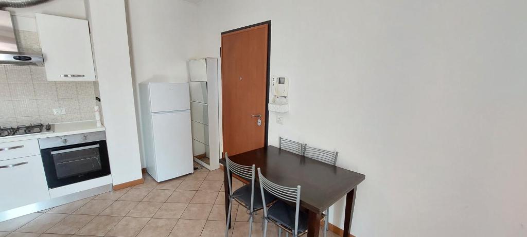 a kitchen with a table and chairs and a refrigerator at Mansuè, appartamento con giardino fra Oderzo e Pordenone in Mansuè