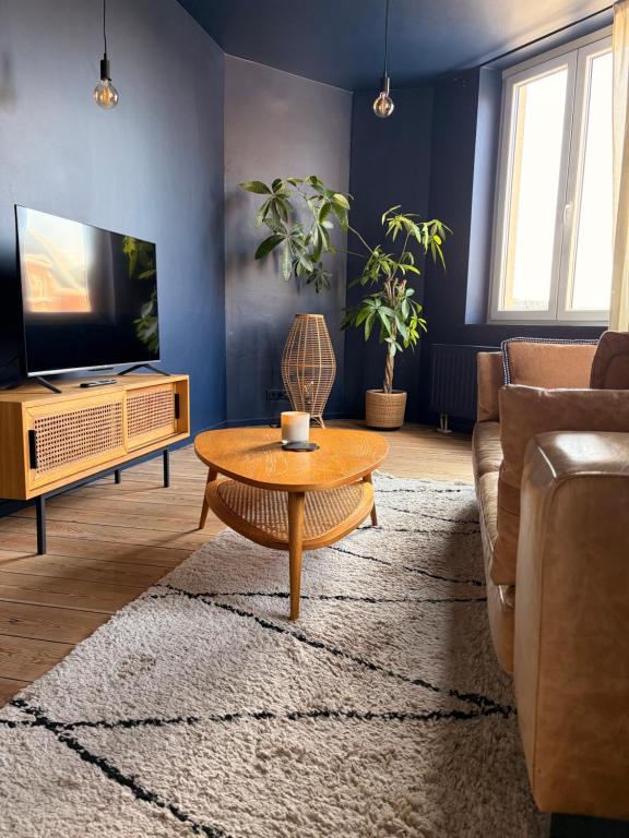 a living room with a couch and a coffee table at Au pied du mur in Huy
