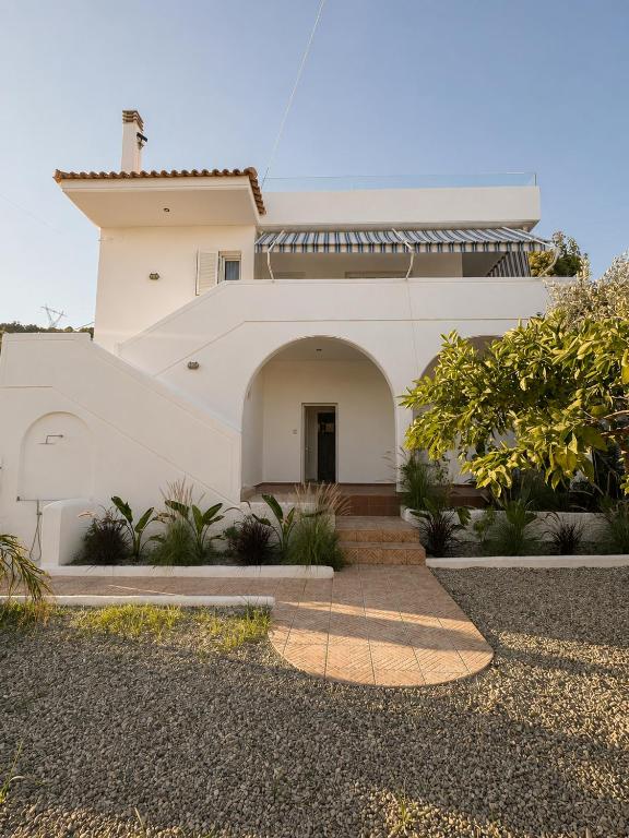 a white house with an archway in front of it at Seascape Nafplio Residence in Vivari