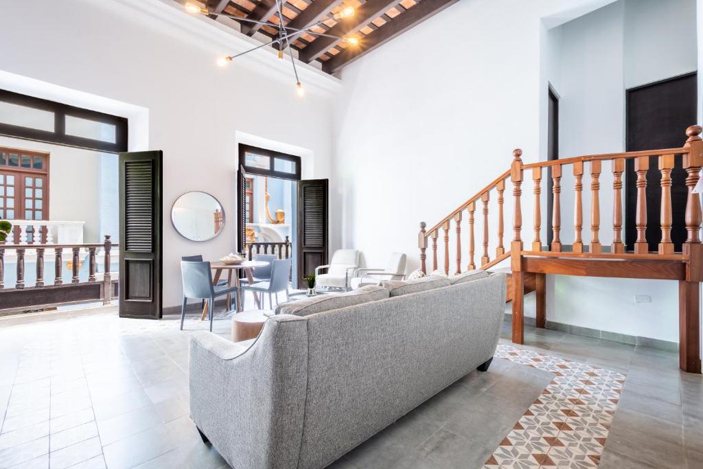 a living room with a couch and a staircase at Casa Las Ruinas Boutique Hotel in San Juan