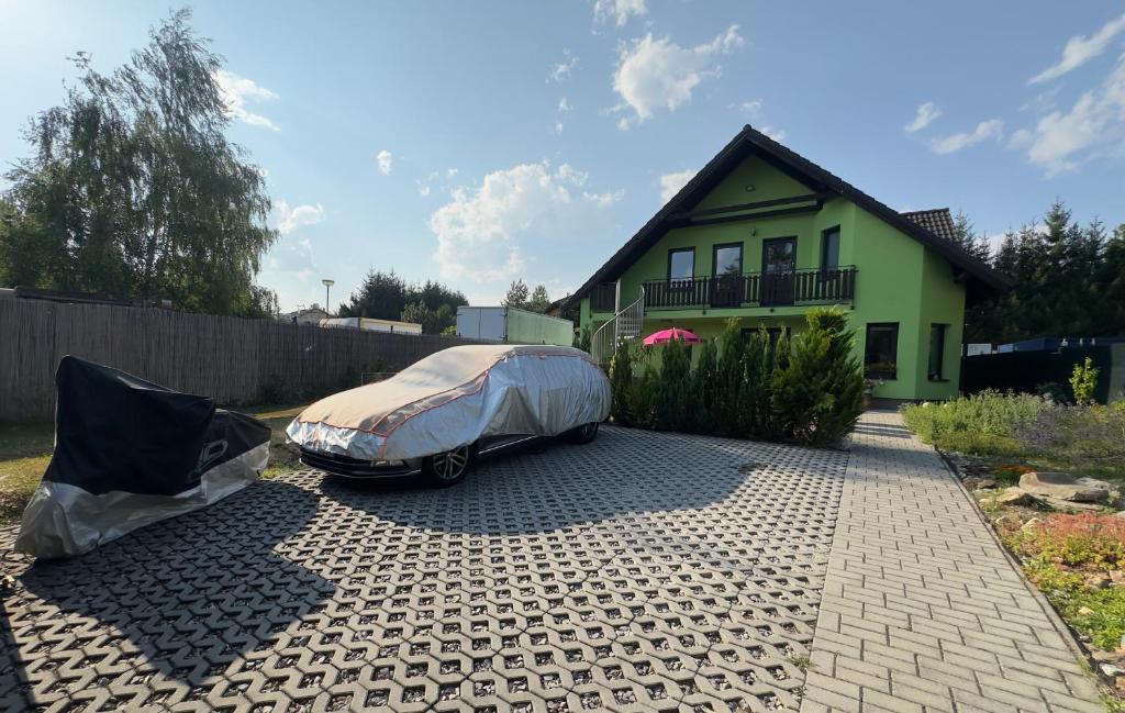 a car with a cover parked in front of a house at Apartmán TINA in Rudolfov