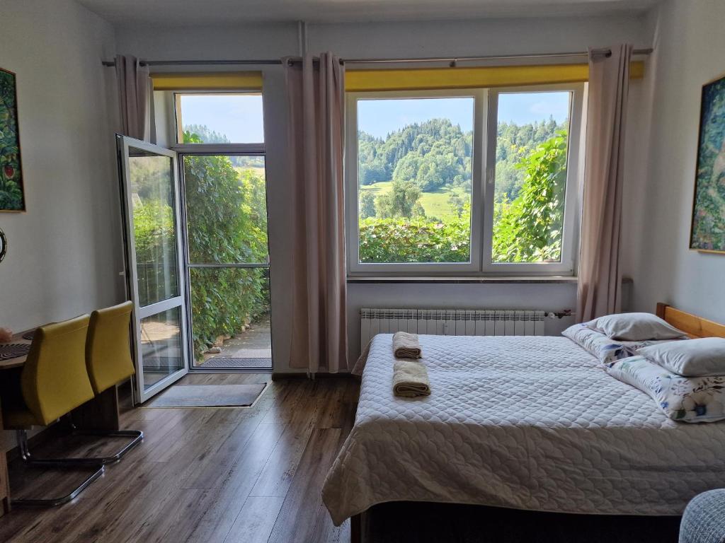 a bedroom with a bed and a large window at Zielona Przystań Apartament z widokiem na Pieniny in Jaworki