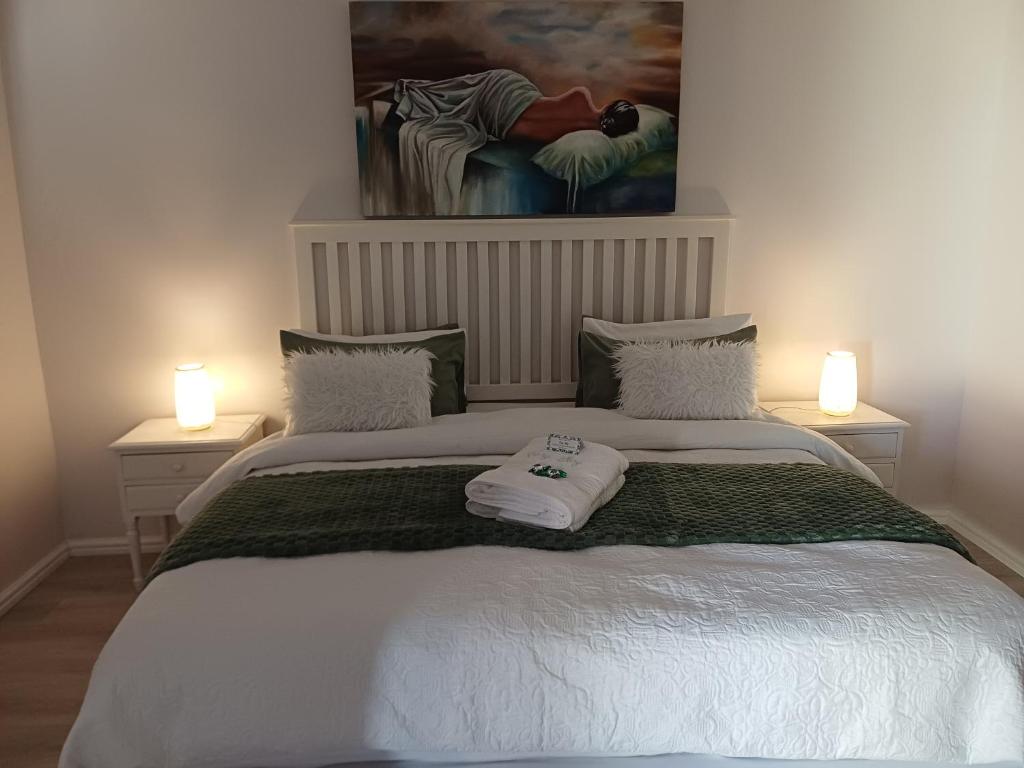 a bedroom with a bed with two lamps and a painting at Cosy Stay in Robertson