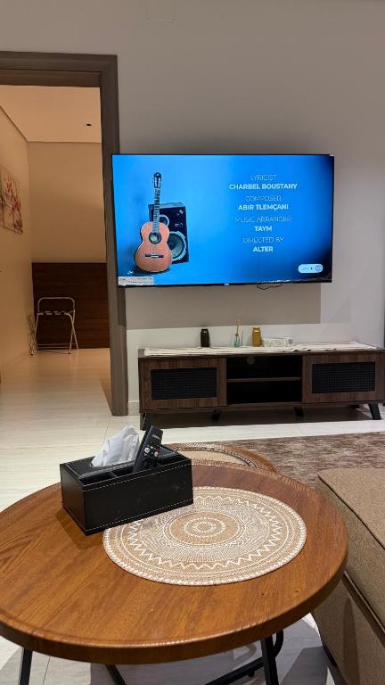 ein Wohnzimmer mit einem Tisch und einem Flachbildfernseher in der Unterkunft هاوس تو 21 in Abha