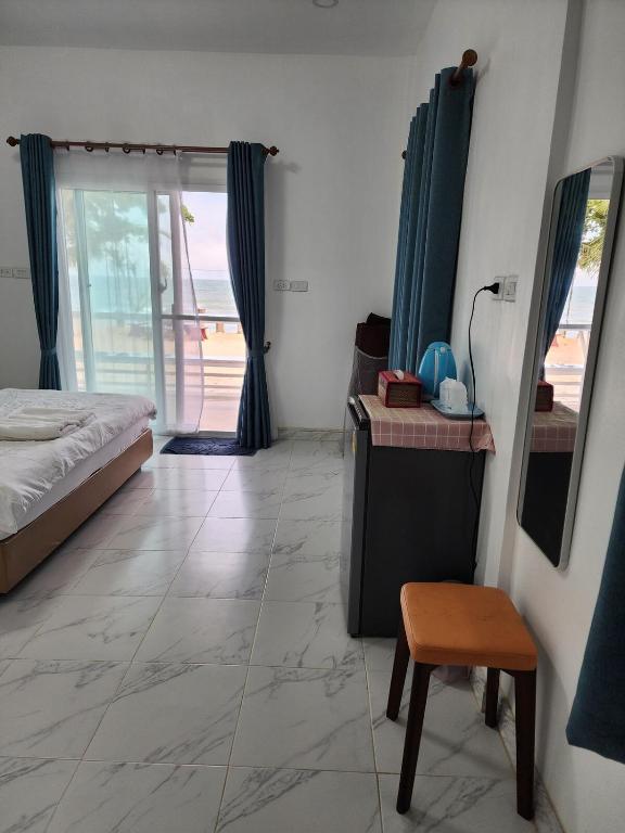 a bedroom with a bed and a table and a chair at Chomlay House in Ban Thepha
