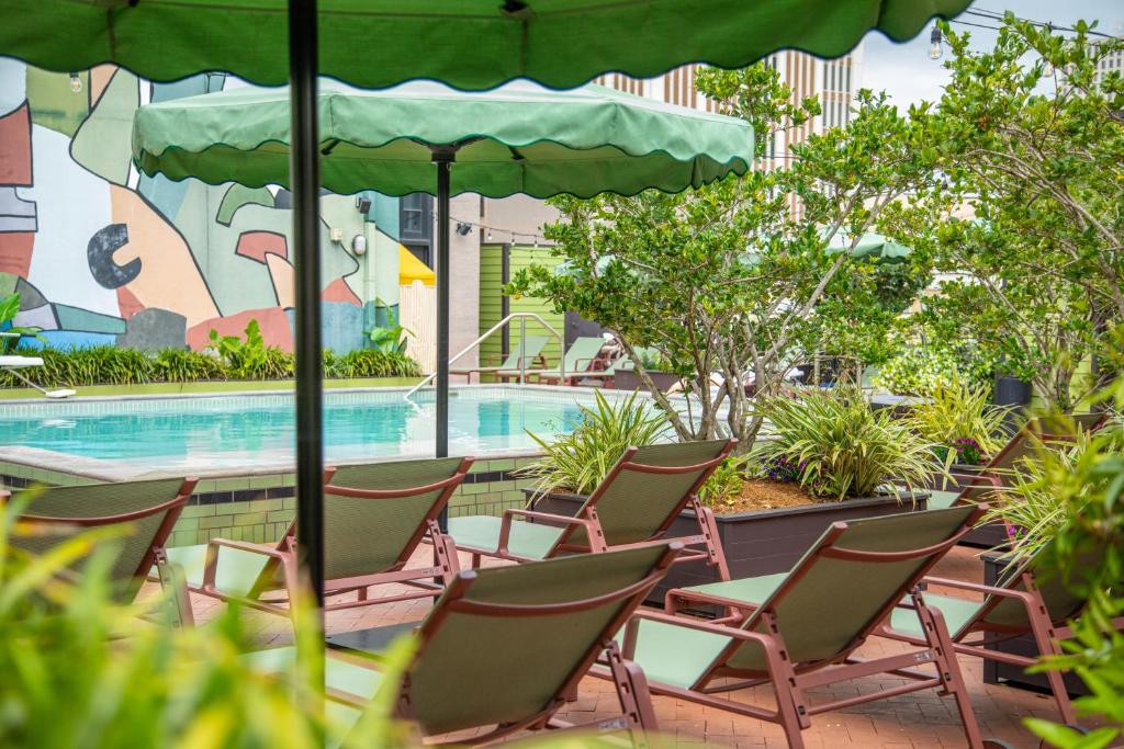 a group of chairs and an umbrella next to a swimming pool at The Barnett JDV by Hyatt in New Orleans