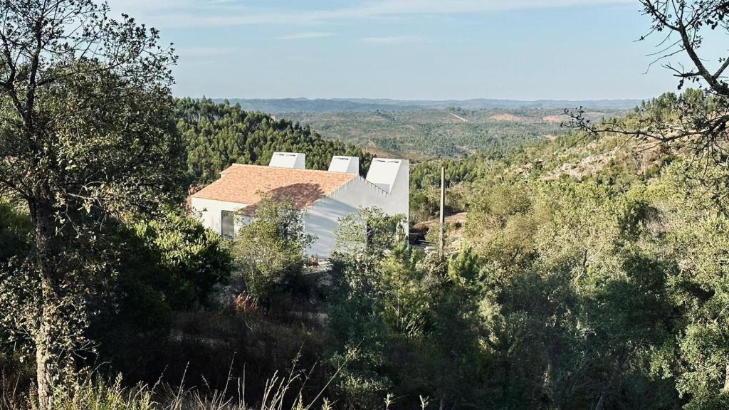 a white house in the middle of a mountain at Vale De Água Equestrian Resort in Odemira