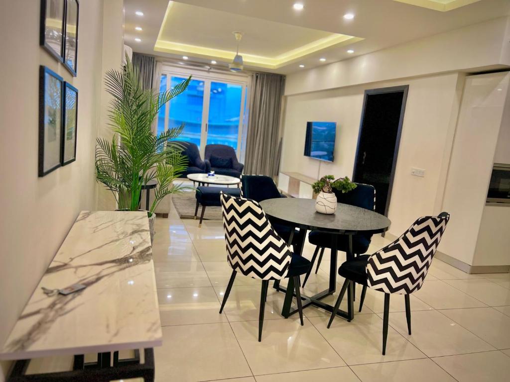 a kitchen and living room with a table and chairs at SkyPark Premium Hotel Serviced Apartments - LMY Hospitality Gulberg Islamabad in Islamabad