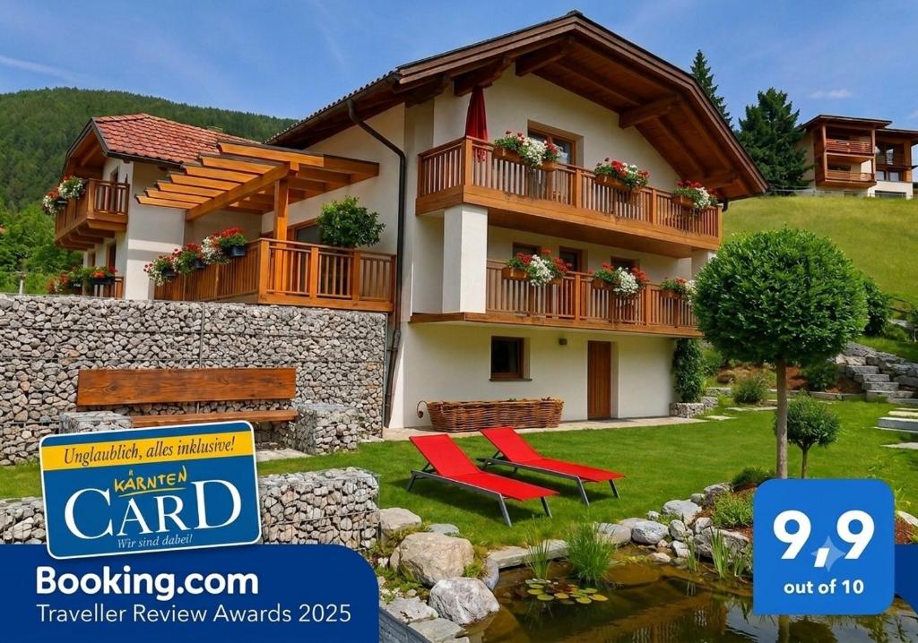 a house with two red chairs in front of it at Chalet Catina in Bad Kleinkirchheim