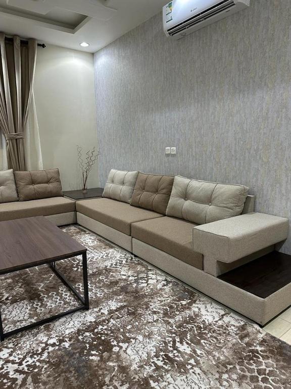 a living room with a couch and a table at فندق أوريون orion hotel in Al-ʿUla