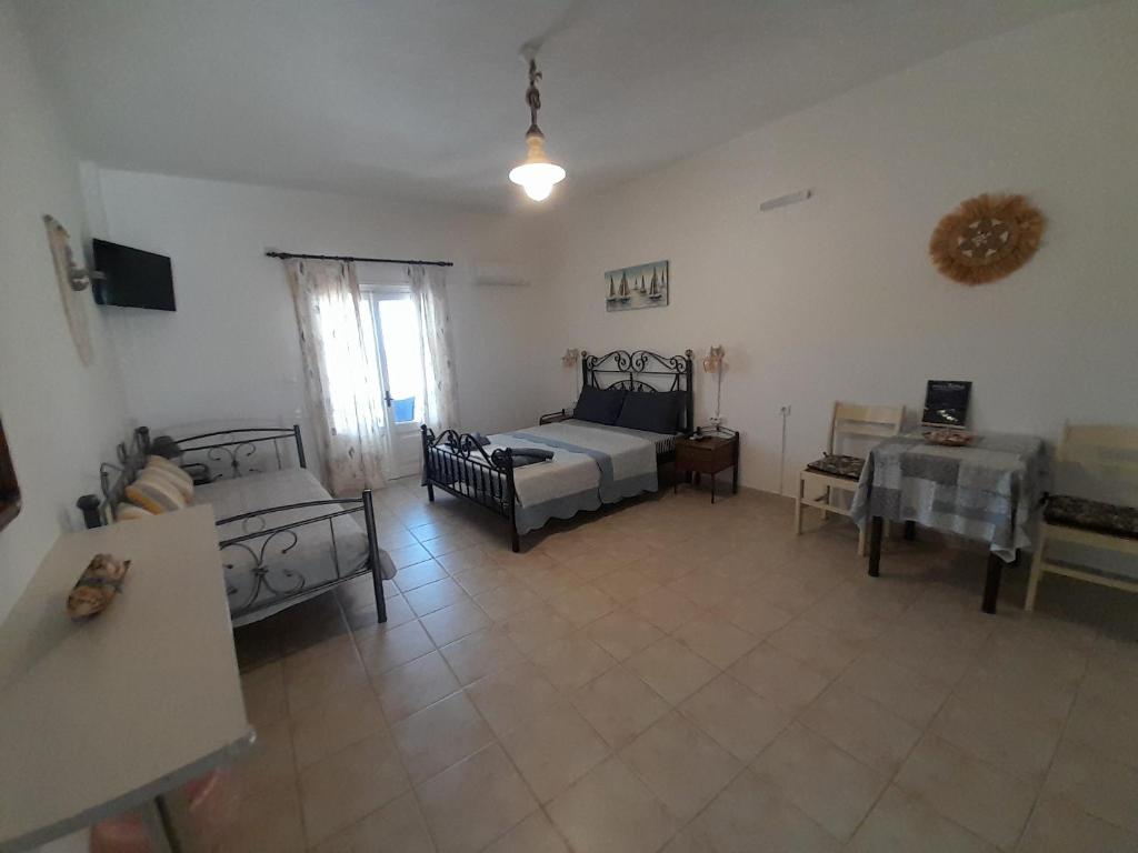 a large room with a bed and a table at Studios RENA in Fournoi