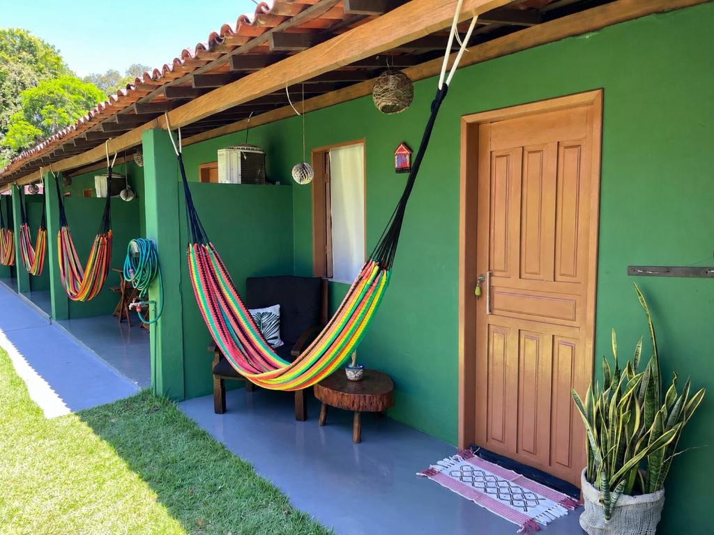 a room with two hammocks in a house at Caju com Mel Hospedagem in Moreré