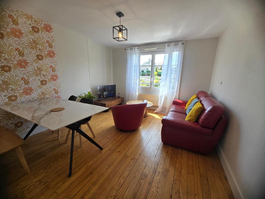 a living room with a red couch and a table at Atria SILS in Caen