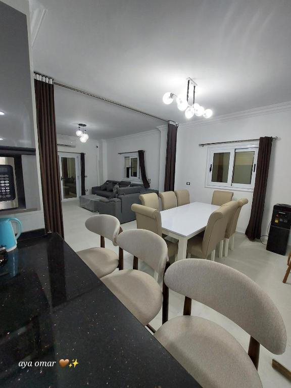 a living room with a white table and chairs at Royal Green Haven 3BR Apartment near Airport Obour in Obour