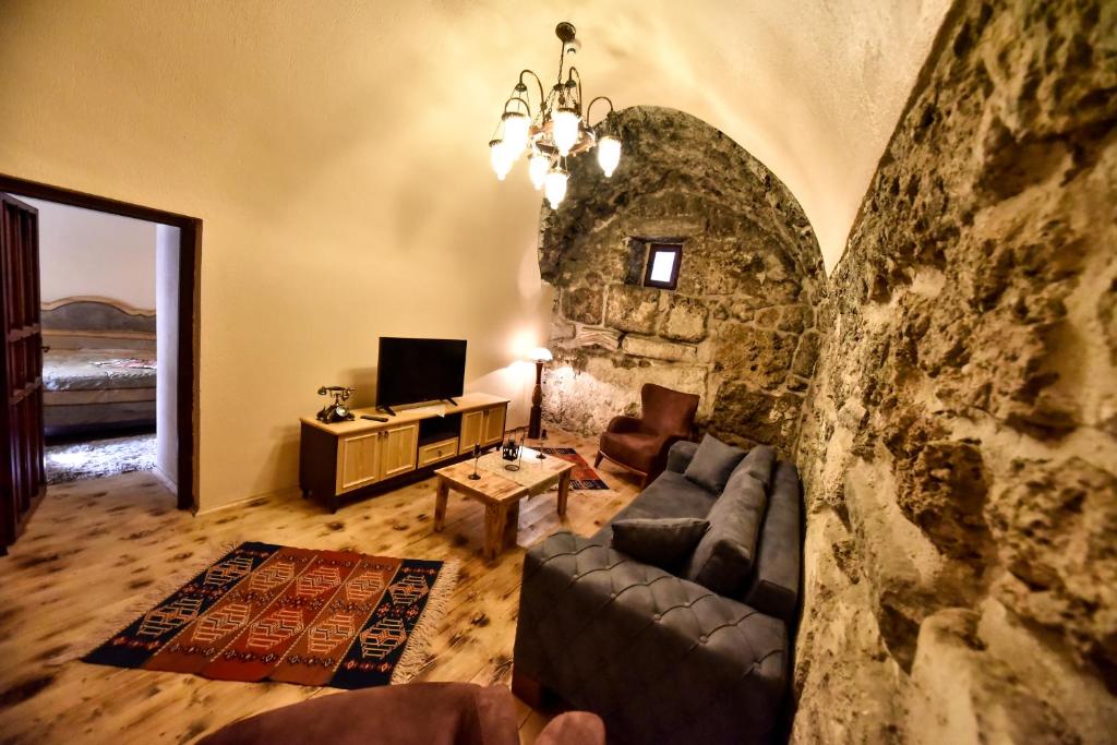 a living room with a couch and a stone wall at Akhan Kervansaray Hotel in Eskihisar