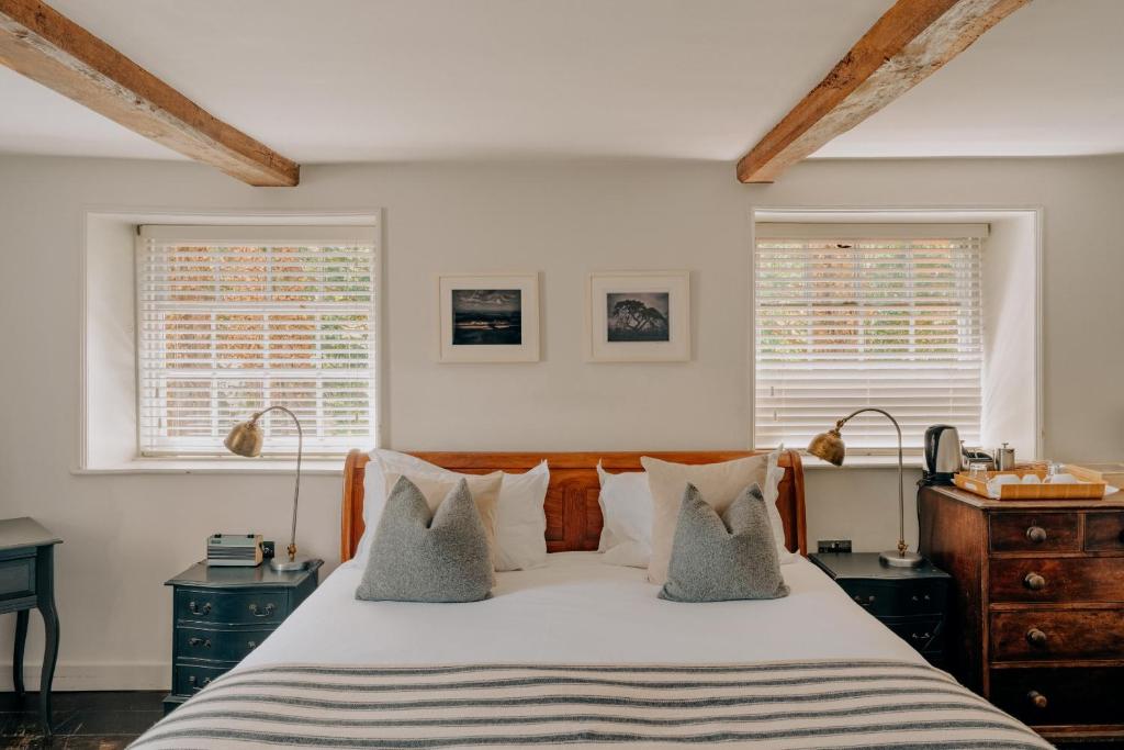 a bedroom with a large bed with two windows at The Ram Inn in Lewes