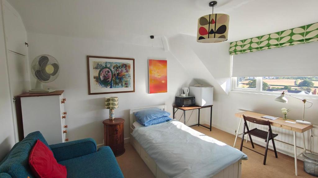 a living room with a bed and a desk at 15 Aller Park Rd, Newton Abbot in Newton Abbot