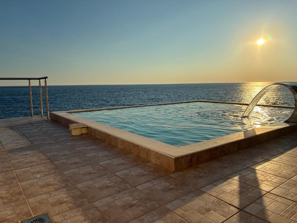 a swimming pool with the ocean in the background at Villa Bakic in Dobra Voda