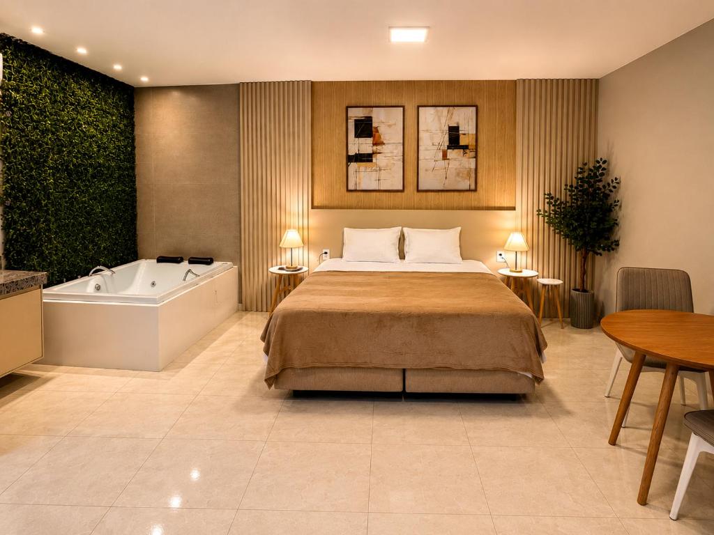 a bedroom with a bed and a bath tub at Exclusive Hotel in Campos Sales