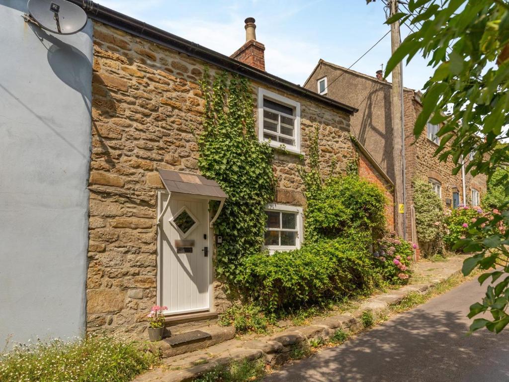 a stone house with a white door and ivy at 3 Bed in Eype oc-e34183 in West Bay