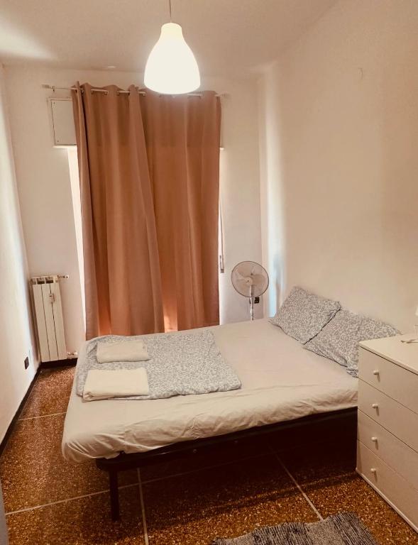 a small bedroom with a bed and a curtain at Private Space near City Center in Genoa
