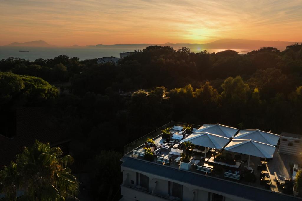 a view of a building with tables and umbrellas at sunset at Hotel Marad in Torre del Greco