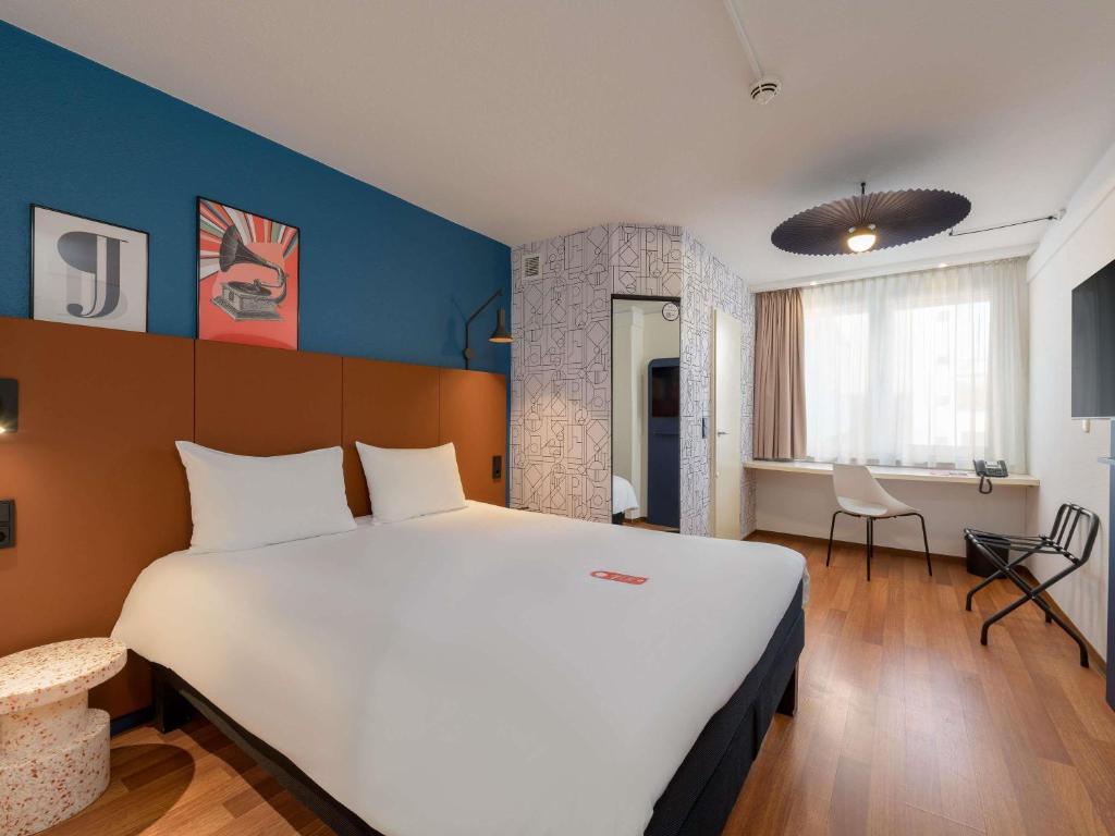 a bedroom with a large white bed in a room at ibis Nürnberg Hauptbahnhof in Nuremberg