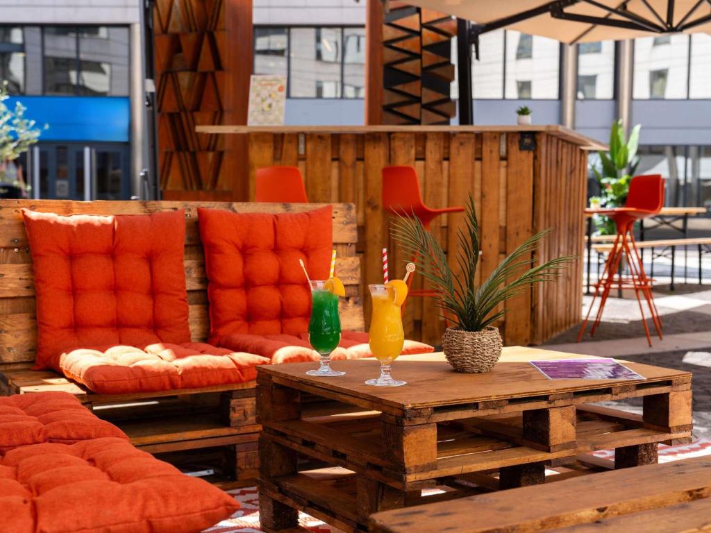 a patio with a table with two drinks on it at Novotel Paris Rueil Malmaison in Rueil-Malmaison