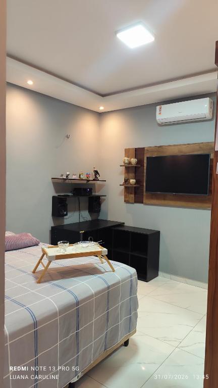 a room with a flat screen tv and a bed at Casa Toda com Garagem a 3km do Aeroporto in Teresina