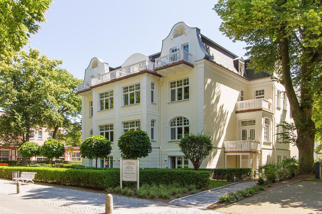 a large white house with a sign in front of it at Ferienwohnungen am Strand - Strandvilla Belvedere in Kühlungsborn