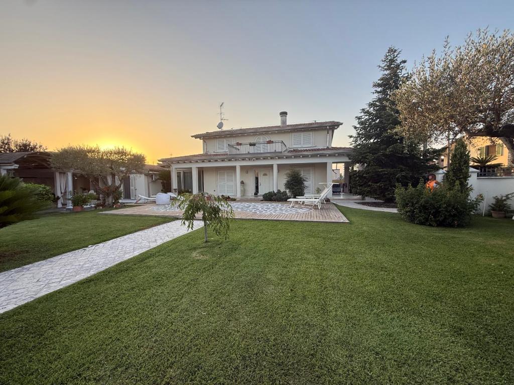 a large white house with a grass yard at Villa Concetta in Torre del Lago Puccini